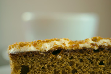 Fresh serving of carrot cake with cup of coffee in background
