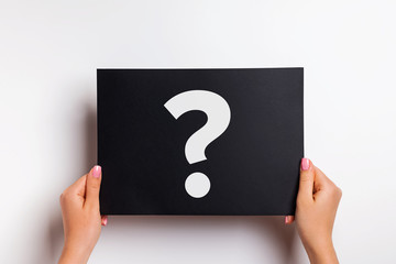 Woman's hands holding black paper with white answer sign