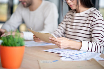 Close up of wife holding envelopes with letters
