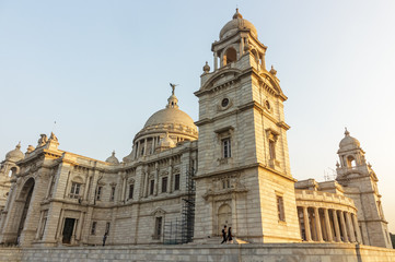 Fototapeta na wymiar Kolkata, West Bengal/India - January 23 2018: Evening light hits the Victoria Memorial, the large elegant colonial monument built of white marble, dedicated to Queen Victoria.