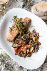 Pan Seared Salmon Steak with Sauteed Vegetables, Greens and Spicy Sauce.