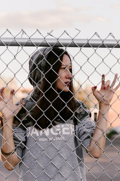 Girl against the rules. Rebel girl near the wired fence. Protesting on street. Stop the border. Hoping for the good future. Girl against the rules. Lack of freedom. Fight for the human right. Hoping.