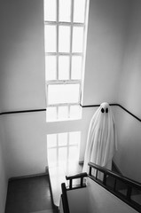 Ghost covered with a white ghost sheet on the stairs of an abandoned psychiatric hospital....