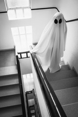 Ghost covered with a white ghost sheet on the stairs of an abandoned psychiatric hospital....