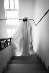 Ghost covered with a white ghost sheet on the stairs of an abandoned psychiatric hospital....