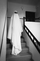 Ghost covered with a white ghost sheet on the stairs of an abandoned psychiatric hospital....