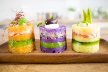 Food photography of the traditional Peruvian dish causa made with 3 different colors of potatoes