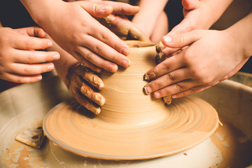 Children's hands make a mold of clay. Pottery