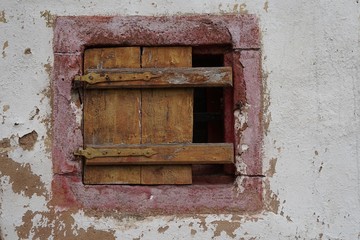 Fototapeta na wymiar Kleines, altes Fenster mit Holzverschlag