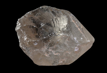 Translucent smoky quartz mineral from Brazil isolated on a pure black background .