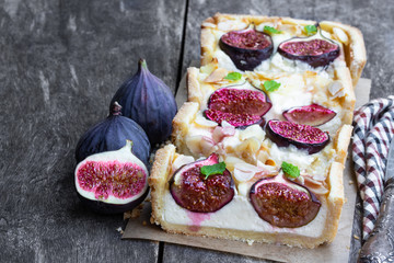 Homemade fig pie with brie cheese and almonds on wooden table