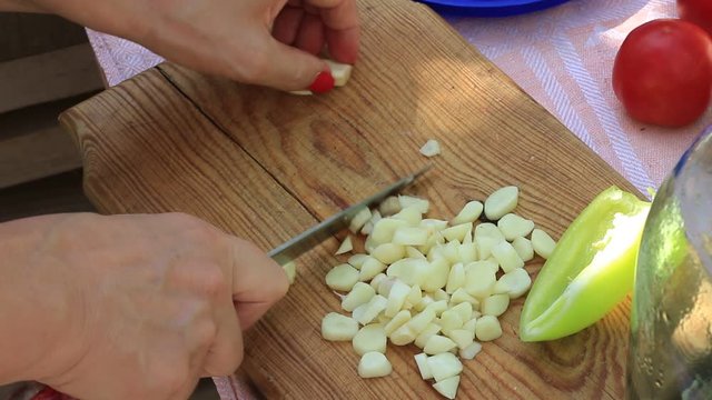 Woman chopping garlic on a cutting board