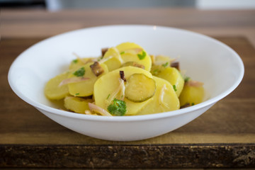 Food photography of a traditional German potato salad in a white bowl
