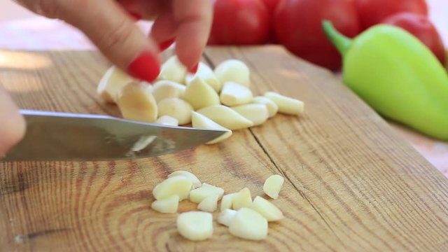Woman chopping garlic on a cutting board