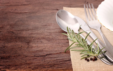 fork, knife and spices on wooden table