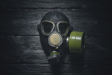 Gas mask on a black wooden background. Post apocalypse.