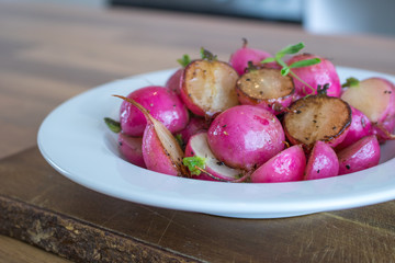Food photography of sautéed radishes in a while bowl