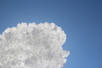 a piece of ice glistens in the sun against the sky