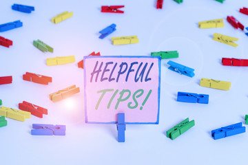Text sign showing Helpful Tips. Business photo text advices given to be helpful knowledge in life Colored clothespin papers empty reminder white floor background office