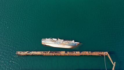 Aerial photo of shipwreck abandoned to rust in industrial bay of Elefsina, Attica, Greece