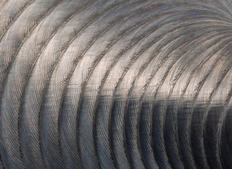 Close-up of industrial gray stainless steel flat part in partial focus after industrial CNC routing...