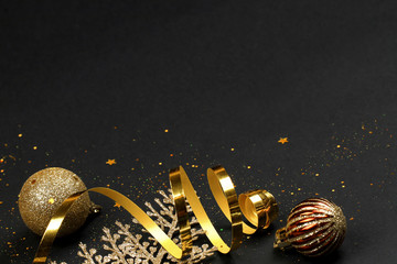 Golden branches, balls, serpentine and confetti on a black background. Christmas.