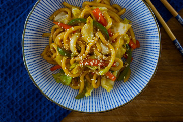 Food photography of the Japanese dish yaki udon in an asian bowl and a blue cloth