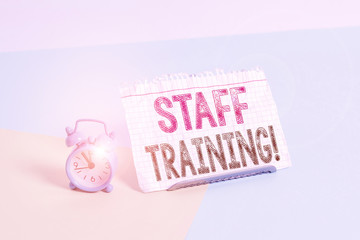 Word writing text Staff Training. Business photo showcasing learn specific knowledge improve perforanalysisce in current roles Mini size alarm clock beside a Paper sheet placed tilted on pastel