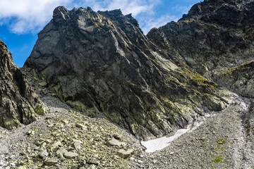 Fototapeta na wymiar Peak - Wschodni Szczyt Zelaznych Wrot (Vychodny Zelezny stit) - one of the numerous peaks lying on the line of the Main Ridge of the Tatra Mountains - view in summer and autumn conditions.