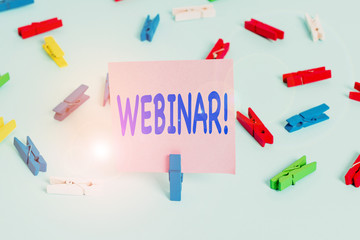 Text sign showing Webinar. Business photo showcasing seminar or other presentation types that takes place on Internet Colored clothespin papers empty reminder blue floor background office pin