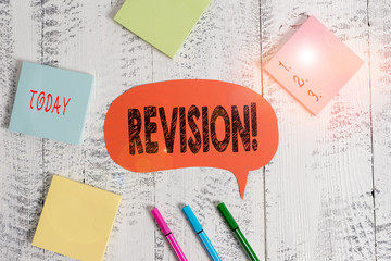 Text sign showing Revision. Business photo text action of revising over someone like auditing or accounting Ballpoints pens blank colored speech bubble sticky notes wooden background