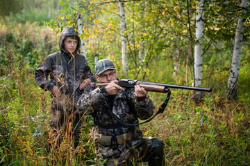 A ranger teaching his son about spotting the game in the wilderness