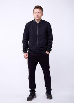 Young Man In Jeans, Black Bomber Jacket On White Background.