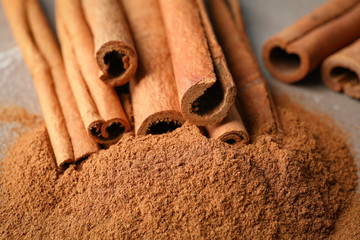 Cinnamon sticks and powder on grey background, closeup