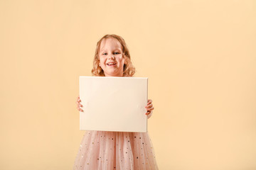 Cute curly girl of four years old. laughs emotionally. In a smart pink dress.Girl holding white blank paper vertically. Leaflet presentation. Pamphlet hold hands. Woman show clear offset paper.