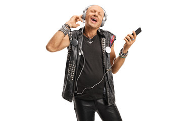 Punk listening to music on headphones plugged into a mobile phone
