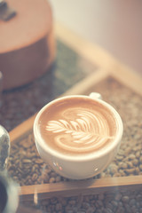 Coffee cup on glass table in cafe with morning lighting background.soft focus,motionblur