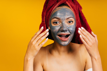yellow studio. girl shows a black face mask