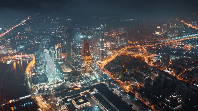 Beautiful aerial timelapse of Moscow City Center on the night with bright glittering lights of buildings, streets and traffic. Camera moving around showing amazing cityscape from above.