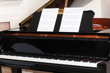 Black grand piano in prepaaration for a recital.