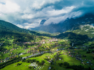 Fototapeta na wymiar Sun shines over Swiss village Grindelwald after heavy storm in summer time near Swiss Alps