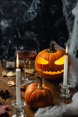 Halloween table with jack o lantern, spider web, candles and smoke