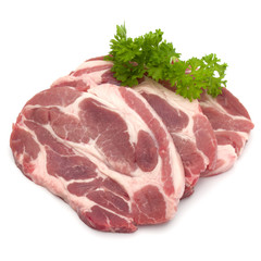 Raw pork neck chop meat with parsley herb leaves garnish isolated on white background cutout