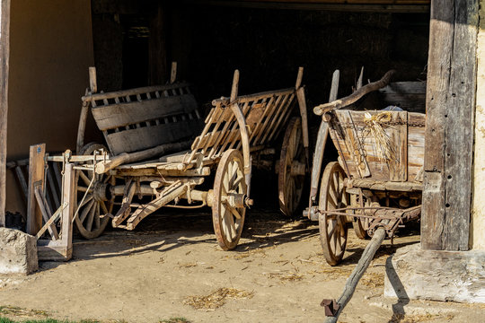 old barn with agricultural weathered wooden chariot