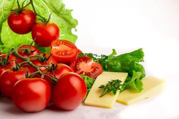 ripe tomatoes with lettuce leaves on a white background