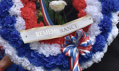 A closeup of the bottom portion of a silk flower veterans memorial day wreath with a small banner...