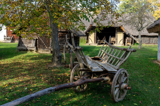 old barns with agricultural weathered wooden chariot in an old village
