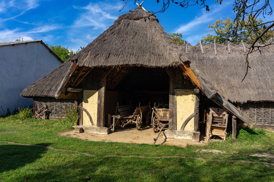 old barn with agricultural weathered wooden chariot in an old village