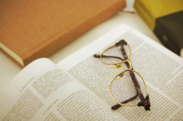 Glasses on a book opened by one of its pages