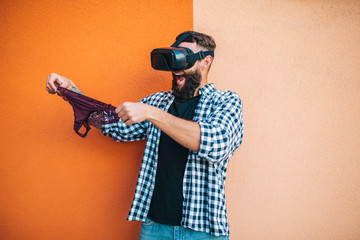 Virtual sex concept. Man in VR glasses play cybersex games and holding female panties in his hands.